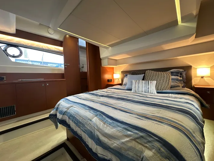  Yacht Photos Pics Luxurious bedroom interior of a 2015 Prestige 500 S yacht with striped bedding.
