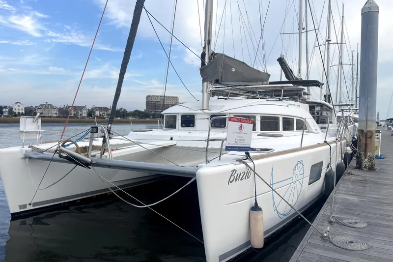 Buzio Yacht Photos Pics 2014 Lagoon 380 S2 catamaran docked, for sale, with clear sky and waterfront view.