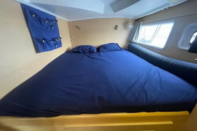 Buzio Yacht Photos Pics Cozy cabin interior of 2014 Lagoon 380 S2 with blue bedding and window view.