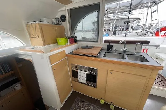 Buzio Yacht Photos Pics Interior of 2014 Lagoon 380 S2 catamaran kitchen with wooden cabinets and dual sinks.