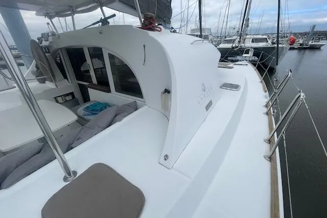 Buzio Yacht Photos Pics 2014 Lagoon 380 S2 catamaran docked at marina, showcasing spacious deck and seating area.
