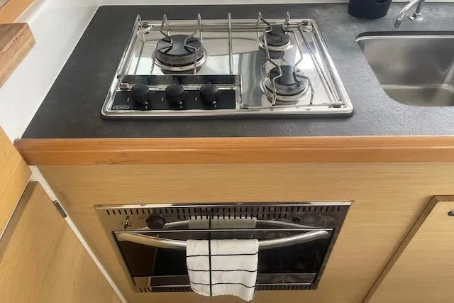 Buzio Yacht Photos Pics Compact kitchen in 2014 Lagoon 380 S2 yacht with stove, oven, and sink.