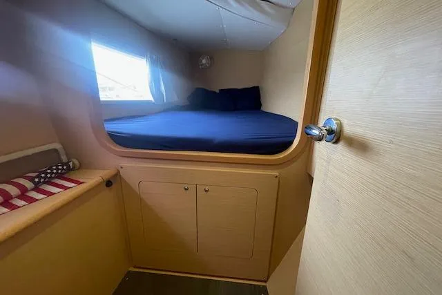 Buzio Yacht Photos Pics Cozy cabin interior of 2014 Lagoon 380 S2 catamaran with bed and window.