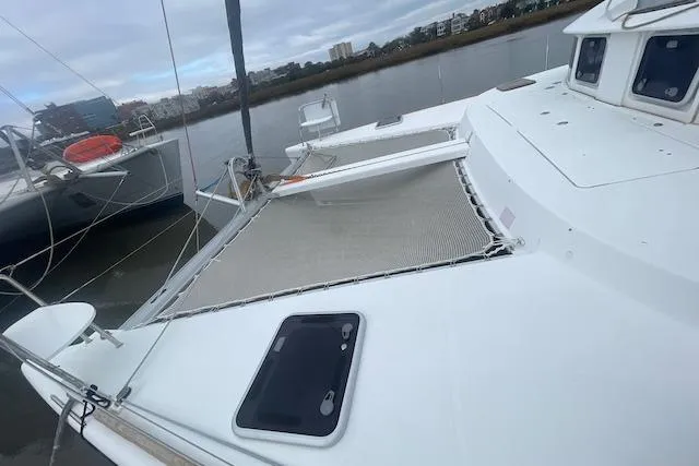 Buzio Yacht Photos Pics 2014 Lagoon 380 S2 catamaran docked by the river, showcasing deck and netting.