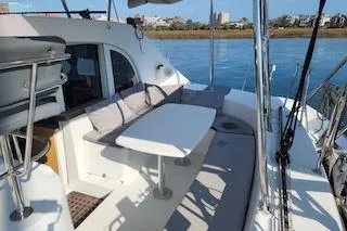 Buzio Yacht Photos Pics 2014 Lagoon 380 S2 yacht with outdoor seating, docked by calm waters.