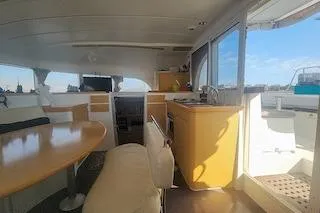 Buzio Yacht Photos Pics Interior of 2014 Lagoon 380 S2 catamaran with dining area and kitchenette.