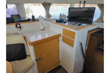 Buzio Yacht Photos Pics 2014 Lagoon 380 S2 interior with TV, radio, and storage cabinets.