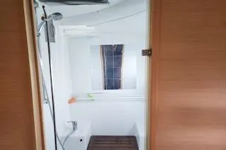 Buzio Yacht Photos Pics Interior view of 2014 Lagoon 380 S2 yacht bathroom with shower and wooden floor.