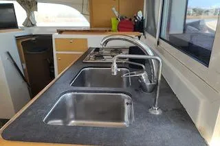 Buzio Yacht Photos Pics Modern kitchen area in a 2014 Lagoon 380 S2 catamaran with dual sinks and sleek countertops.