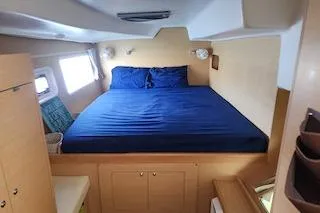 Buzio Yacht Photos Pics 2014 Lagoon 380 S2 yacht cabin with blue bedding and wooden interior.