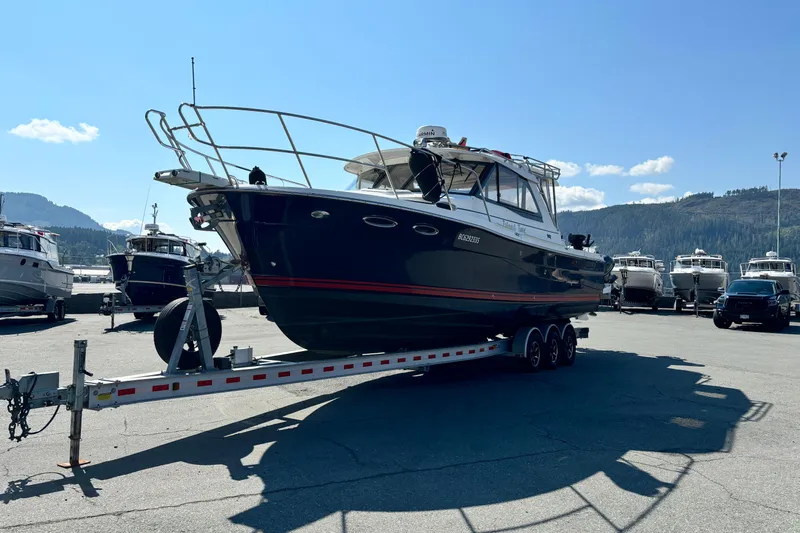  Yacht Photos Pics 2017 Cutwater C-302 Sport Coupe on trailer, parked in marina with mountains in background.