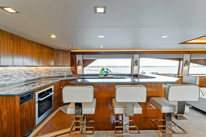 Aussie Rules Yacht Photos Pics Luxurious interior of 2017 Viking 92 Enclosed Bridge yacht with modern kitchen and seating.