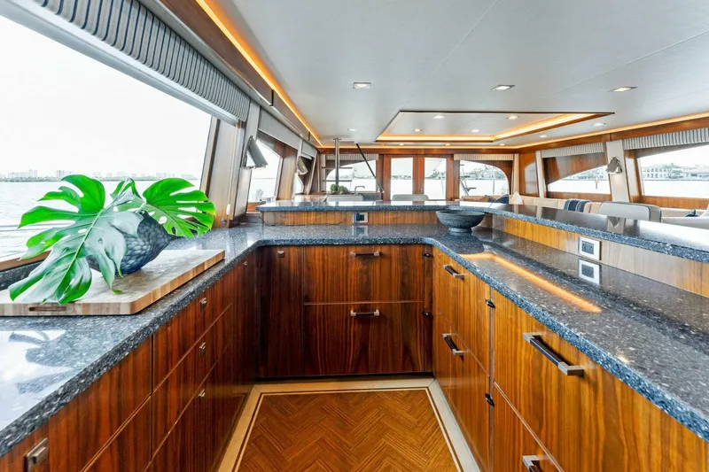 Aussie Rules Yacht Photos Pics Luxurious kitchen interior of 2017 Viking 92 Enclosed Bridge yacht with wood cabinetry.