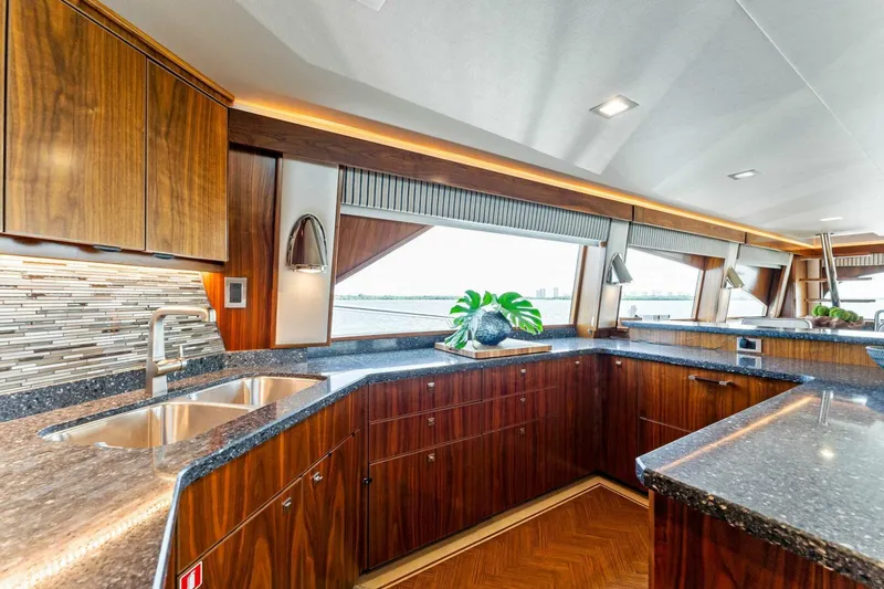 Aussie Rules Yacht Photos Pics Luxurious kitchen interior of 2017 Viking 92 Enclosed Bridge yacht with wood cabinetry and modern design.