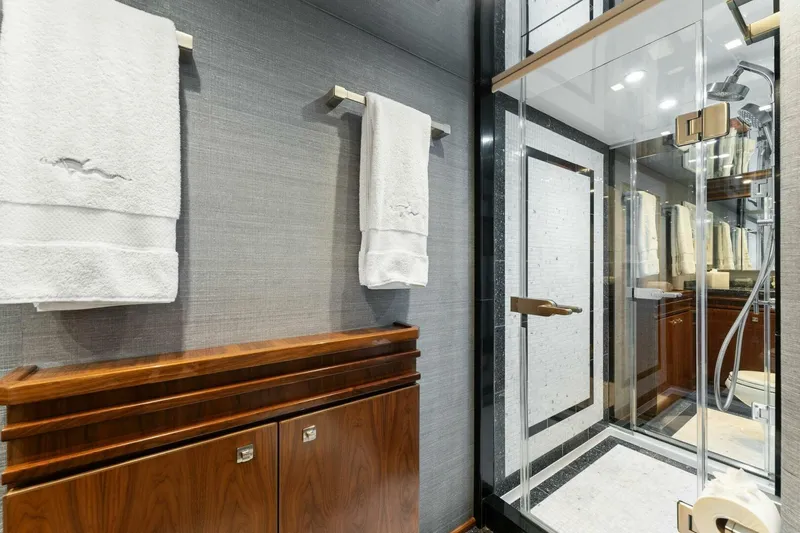 Aussie Rules Yacht Photos Pics Luxurious bathroom in 2017 Viking 92 Enclosed Bridge yacht with glass shower and elegant wood cabinetry.