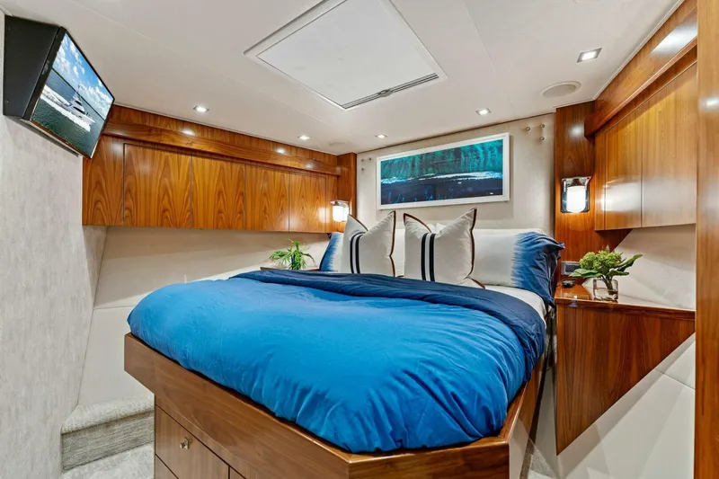 Aussie Rules Yacht Photos Pics Luxurious bedroom in 2017 Viking 92 Enclosed Bridge yacht with blue bedding and wood accents.