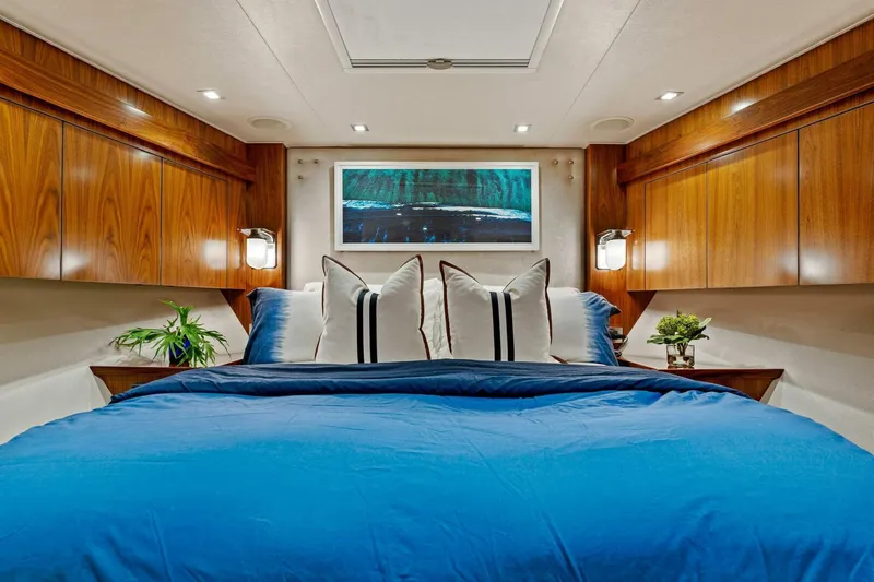 Aussie Rules Yacht Photos Pics Luxurious bedroom interior of 2017 Viking 92 Enclosed Bridge yacht with blue bedding.