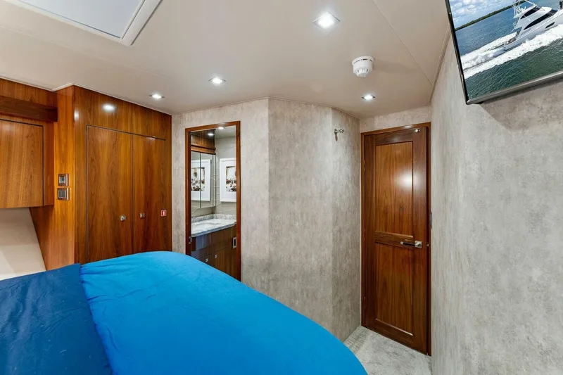 Aussie Rules Yacht Photos Pics Luxurious bedroom interior of 2017 Viking 92 Enclosed Bridge yacht with wood accents.