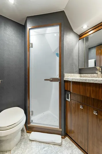 Aussie Rules Yacht Photos Pics Luxurious bathroom in 2017 Viking 92 Enclosed Bridge yacht with modern shower and wood accents.