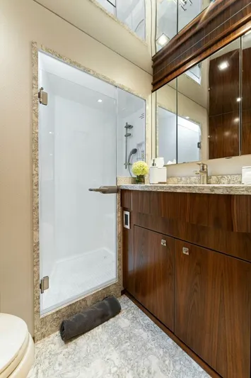 Aussie Rules Yacht Photos Pics Luxurious bathroom in 2017 Viking 92 Enclosed Bridge yacht with modern shower and wooden cabinetry.