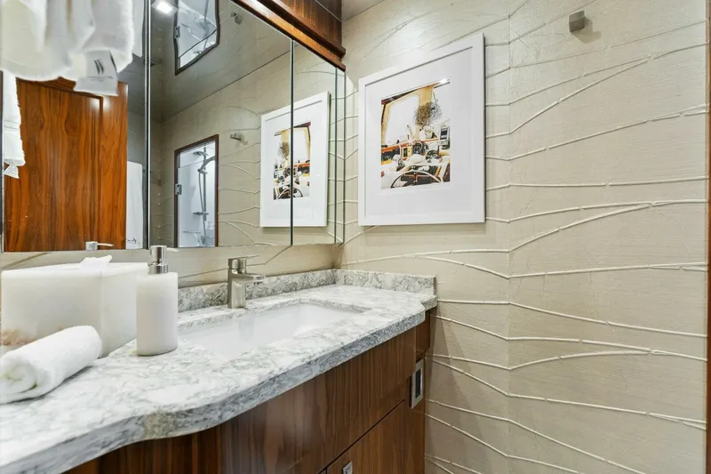 Aussie Rules Yacht Photos Pics Luxurious bathroom in 2017 Viking 92 Enclosed Bridge yacht with marble countertop and modern decor.