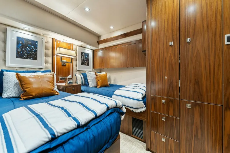 Aussie Rules Yacht Photos Pics Luxurious 2017 Viking 92 Enclosed Bridge yacht bedroom with twin beds and wood cabinetry.