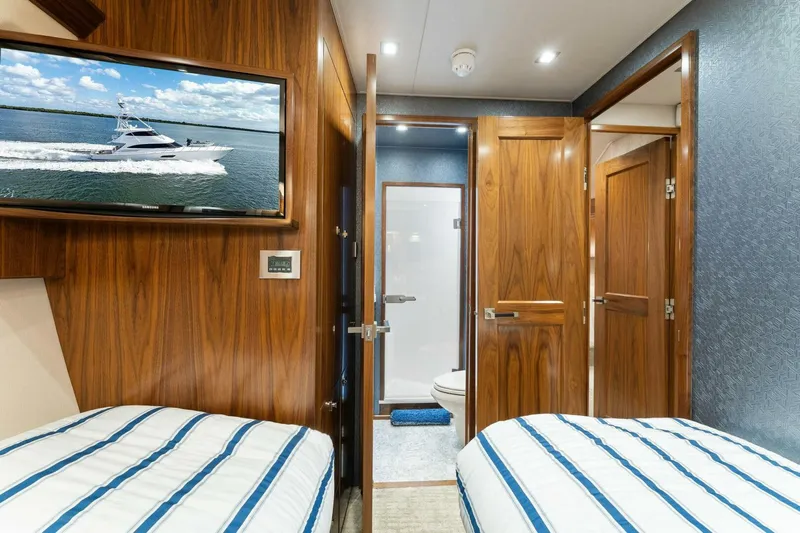 Aussie Rules Yacht Photos Pics Luxurious 2017 Viking 92 Enclosed Bridge yacht interior with twin beds and wood paneling.