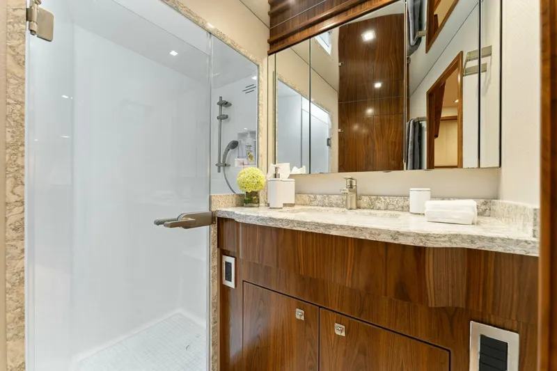 Aussie Rules Yacht Photos Pics Luxurious bathroom in 2017 Viking 92 Enclosed Bridge yacht with modern fixtures and wood cabinetry.