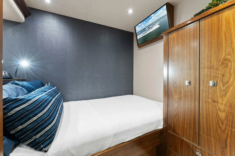 Aussie Rules Yacht Photos Pics Cozy bedroom in 2017 Viking 92 Enclosed Bridge yacht with TV and wooden cabinetry.