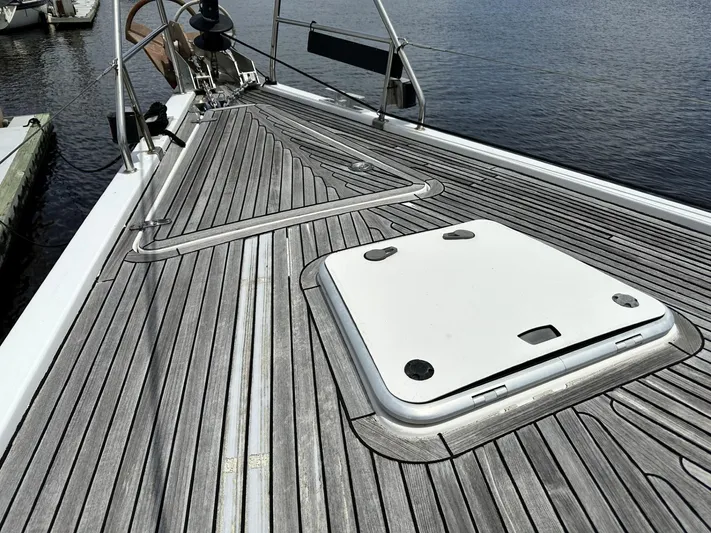 Blue Yacht Photos Pics Deck of 2006 Hanse 461 sailboat with wooden finish and hatch, docked by the water.