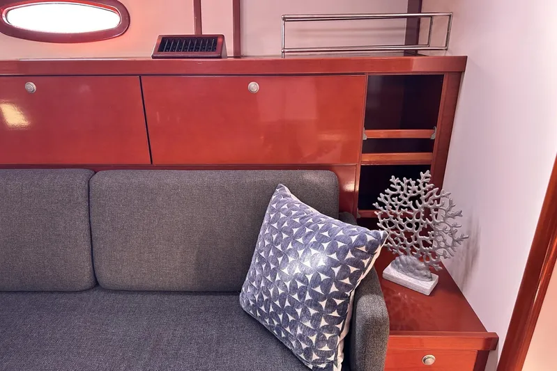 Blue Yacht Photos Pics Interior of 2006 Hanse 461 yacht with gray sofa, decorative pillow, and coral ornament.