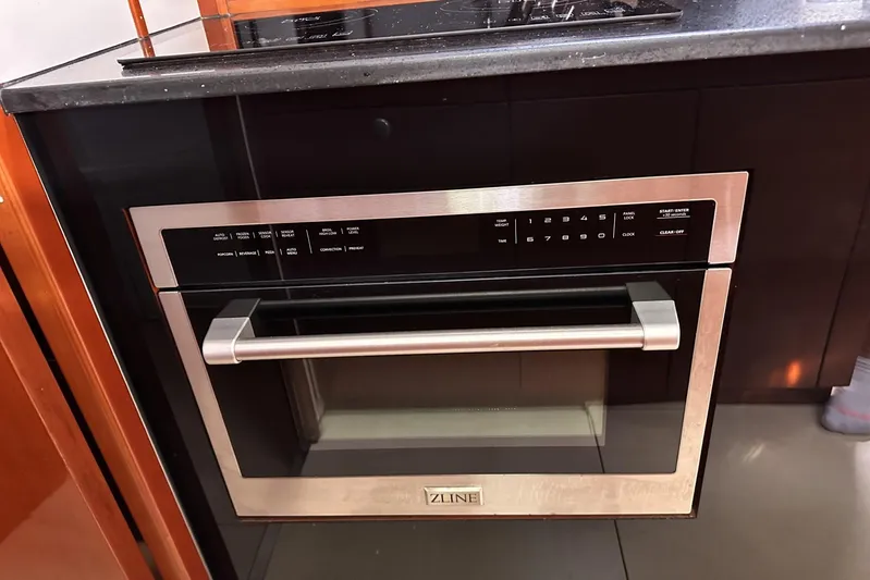 Blue Yacht Photos Pics Modern kitchen with ZLINE oven, sleek black cabinetry, and granite countertop.