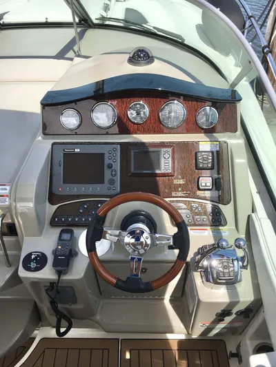  Yacht Photos Pics Helm of 2010 Sea Ray 330 Sundancer with wood accents and modern navigation equipment.