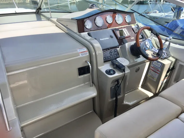  Yacht Photos Pics Helm of 2010 Sea Ray 330 Sundancer with modern controls and wood-accented dashboard.