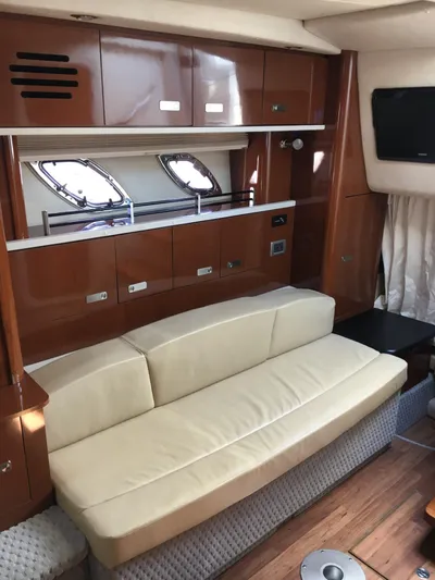  Yacht Photos Pics Interior of 2010 Sea Ray 330 Sundancer with beige sofa and wooden cabinetry.
