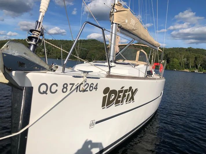  Yacht Photos Pics Dufour 310 Grand Large 2015 sailboat on a tranquil lake.