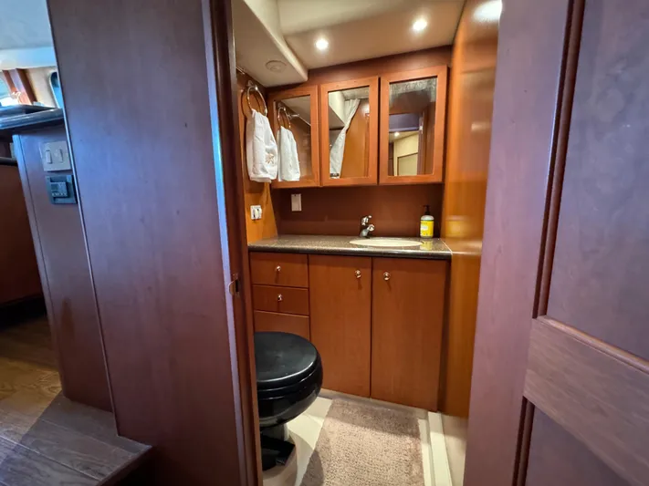 Seas The Reins Yacht Photos Pics Luxurious bathroom interior of 2006 Silverton 43 Sport Bridge yacht, featuring wood cabinetry.