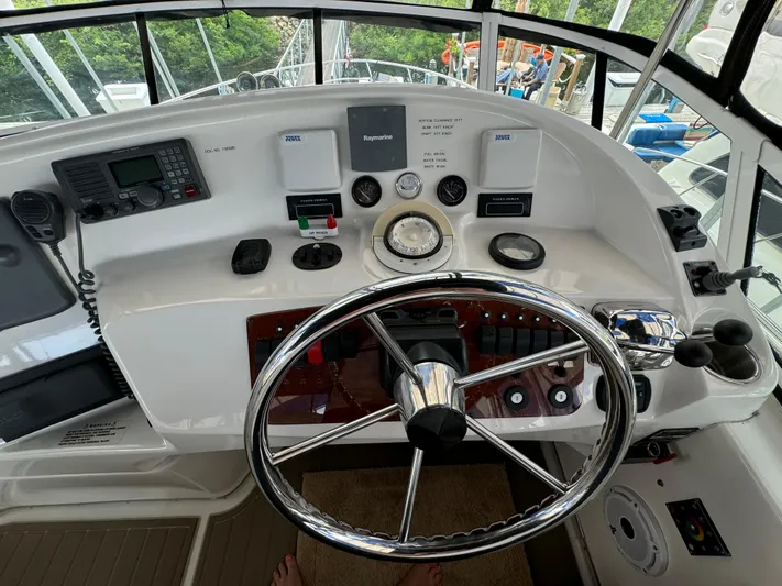 Seas The Reins Yacht Photos Pics Helm of 2006 Silverton 43 Sport Bridge with steering wheel and navigation controls.