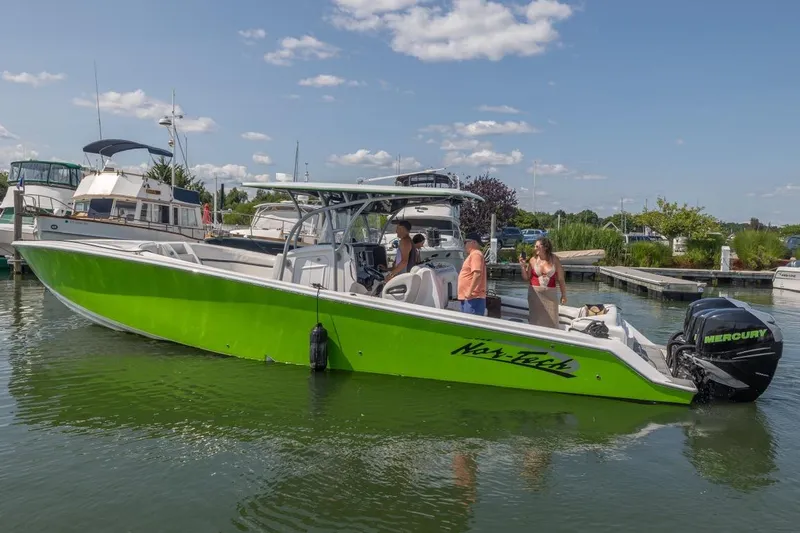  Yacht Photos Pics 2014 Nor-Tech 390 Sport Cuddy Center Console boat in vibrant green, docked with people onboard.
