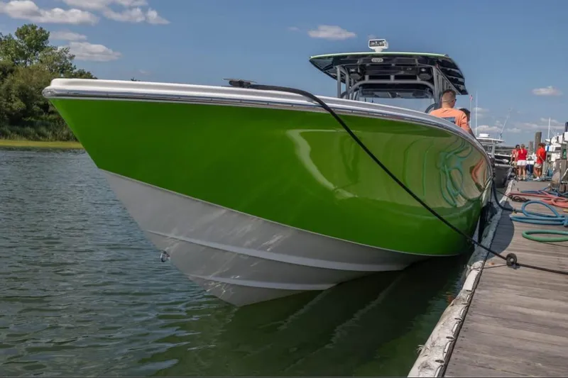  Yacht Photos Pics 2014 Nor-Tech 390 Sport Cuddy Center Console in vibrant green docked by the water.