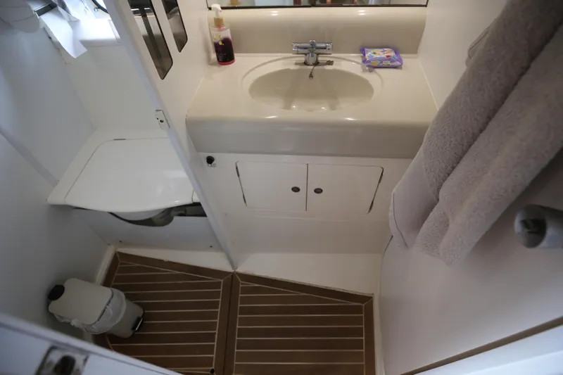  Yacht Photos Pics Bathroom interior of 1993 Princess 366 Riviera yacht, featuring sink, toilet, and wooden floor.