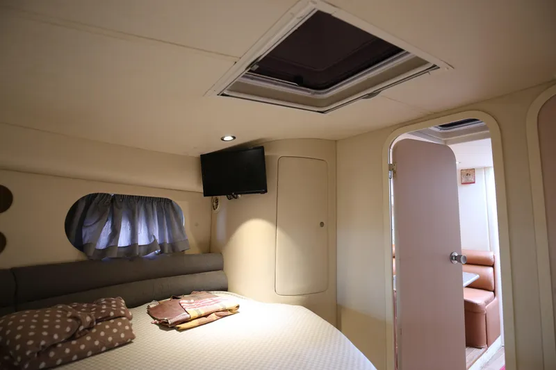  Yacht Photos Pics Cozy cabin interior of 1993 Princess 366 Riviera yacht with bed and TV.