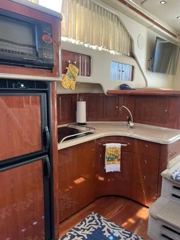 Yacht Photos Pics 2003 Sea Ray 400 Sedan Bridge kitchen with wood cabinetry, microwave, and sink.