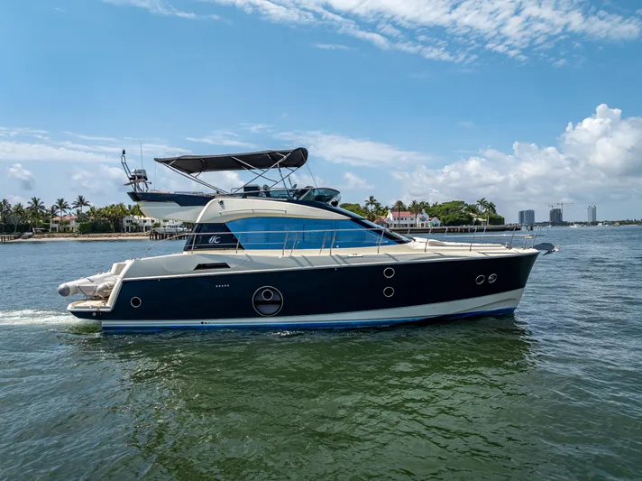 Good Deeds Yacht Photos Pics 2015 Beneteau Monte Carlo 5 yacht cruising on a sunny day near the coastline.