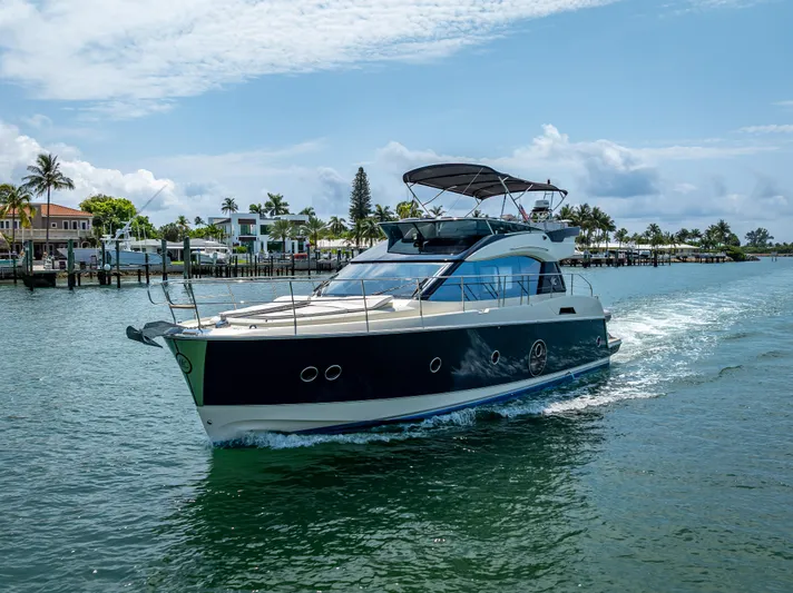 Good Deeds Yacht Photos Pics 2015 Beneteau Monte Carlo 5 yacht cruising on a sunny day near waterfront homes.