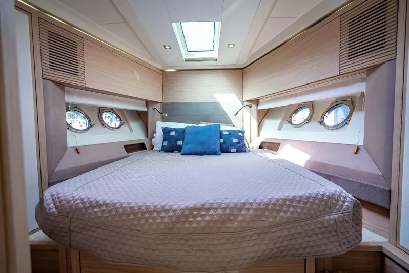 Good Deeds Yacht Photos Pics Luxurious cabin interior of 2015 Beneteau Monte Carlo 5 yacht with skylight and portholes.