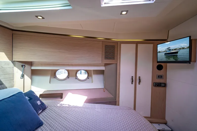 Good Deeds Yacht Photos Pics Luxurious cabin interior of 2015 Beneteau Monte Carlo 5 yacht with TV and portholes.