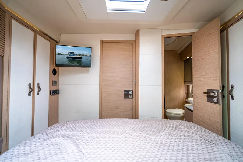 Good Deeds Yacht Photos Pics Luxurious bedroom interior of 2015 Beneteau Monte Carlo 5 yacht with TV and ensuite bathroom.