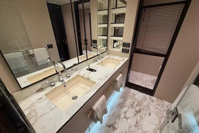  Yacht Photos Pics Luxurious bathroom in 2022 Azimut GRANDE 25 METRI yacht with marble countertops and dual sinks.