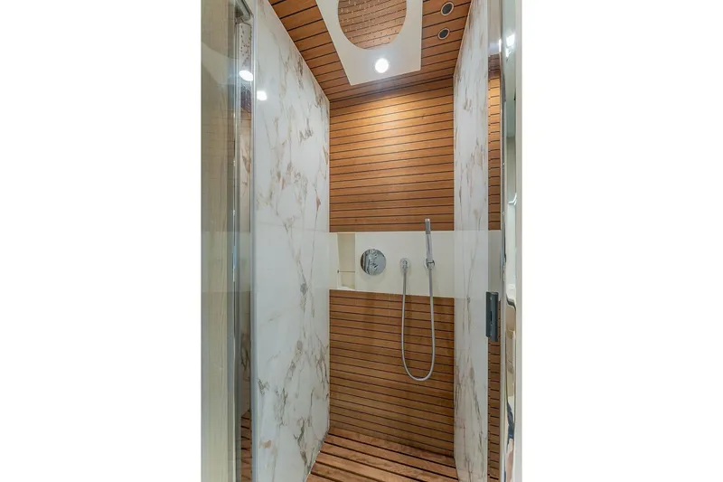  Yacht Photos Pics Luxurious shower in 2022 Azimut GRANDE 25 METRI yacht, featuring wood and marble design.